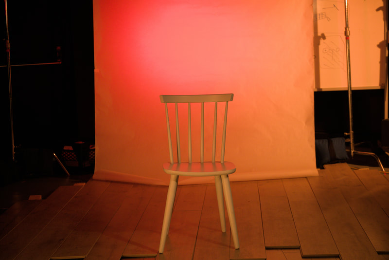 Chair in front of a red-orange background.