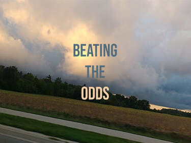 A cloudy landscape with the words 'Beating the Odds' over top of the image