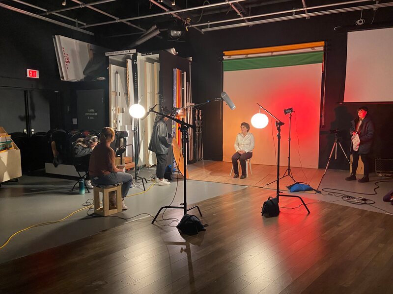 View of the studio space as the director and a subject prepare to shoot an interview.