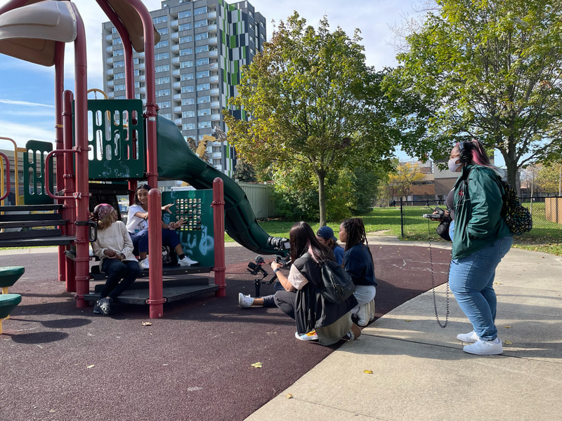 Film crew filming interviews in a child's park